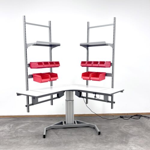 Elektriskt arbetsbord med röda plastbacka och skenor att hänga dem i